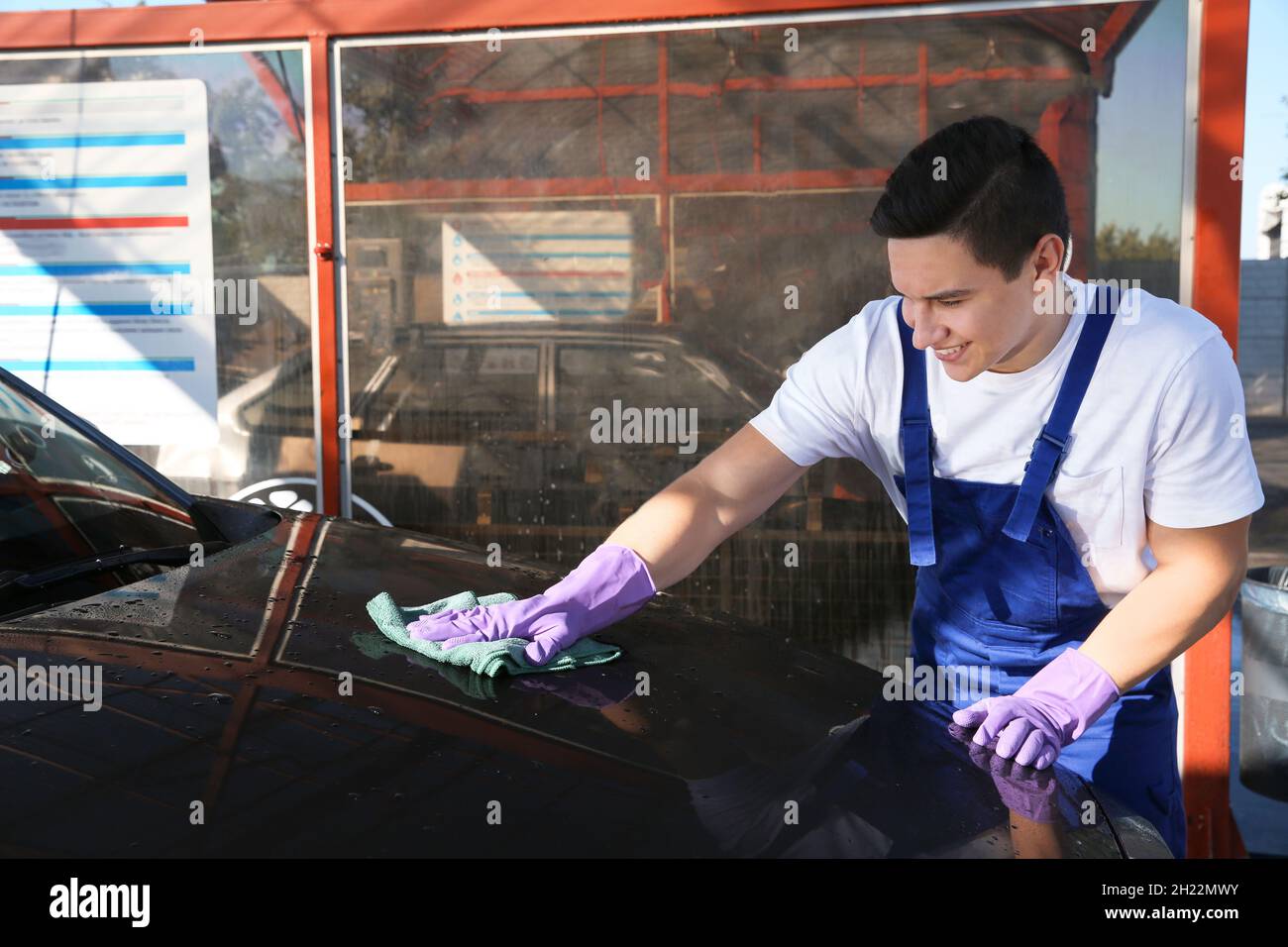 Worker cleaning automobile with rag at car wash Stock Photo Alamy