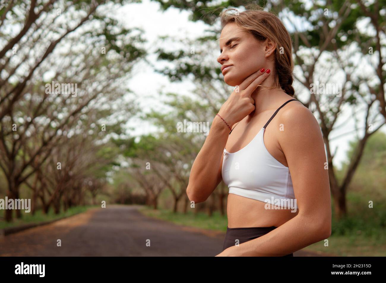 woman checking pulse after running in the forest. bali Stock Photo