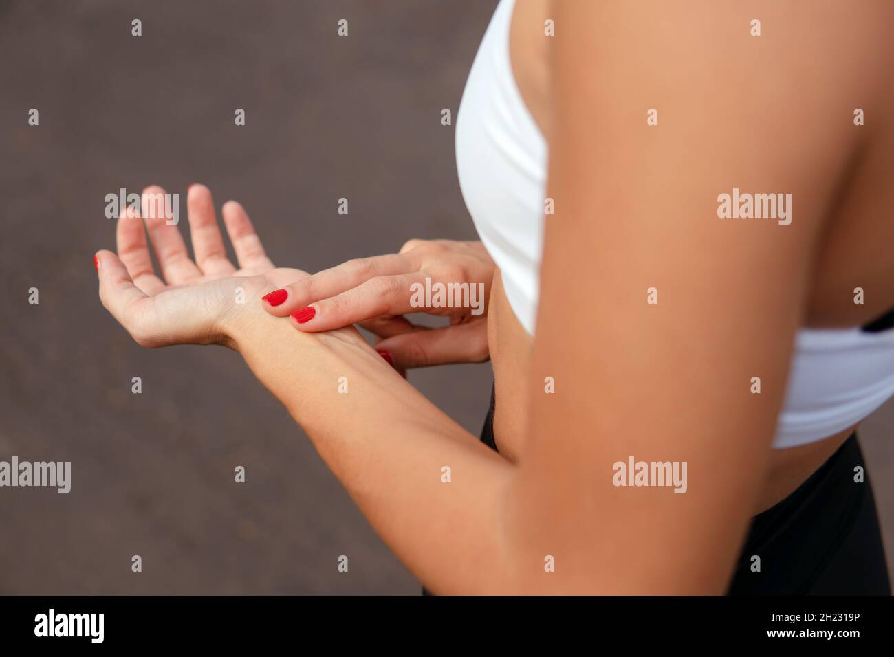 woman checking pulse after running. Hand close-up. Stock Photo