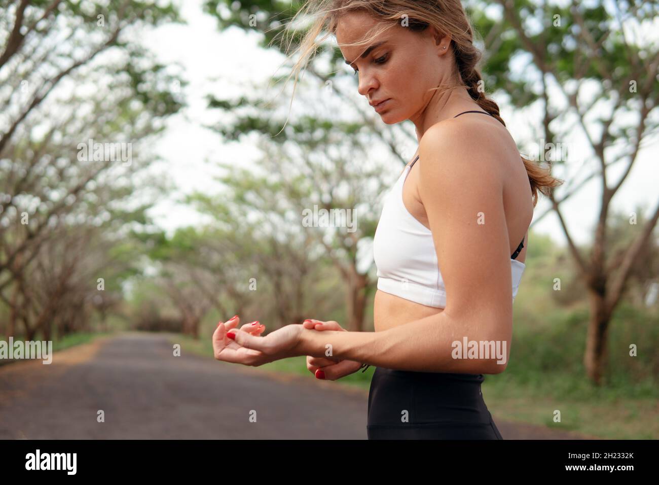 woman in sports wear checking pulse after running.  Stock Photo