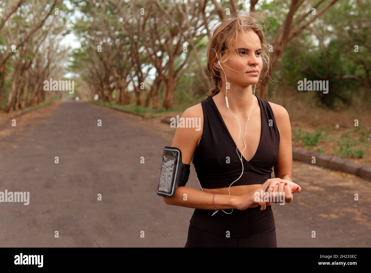 woman in black sportwear checking pulse after running. bali Stock Photo