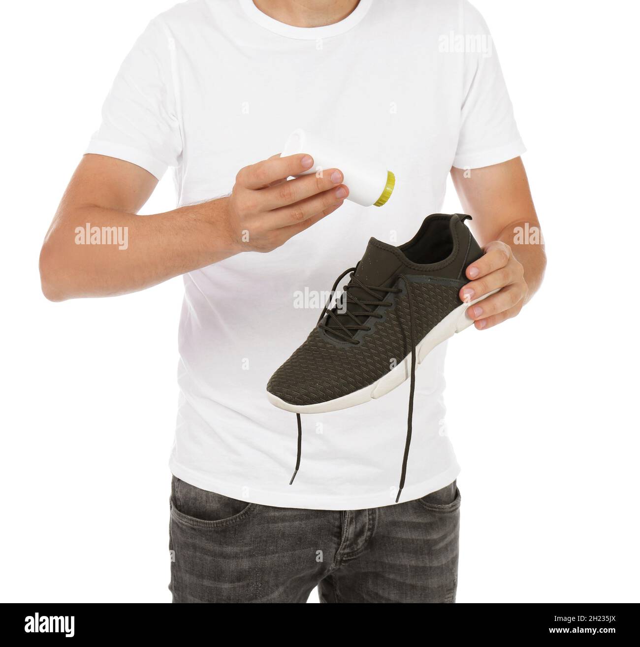 Man putting powder freshener into shoe on white background Stock Photo