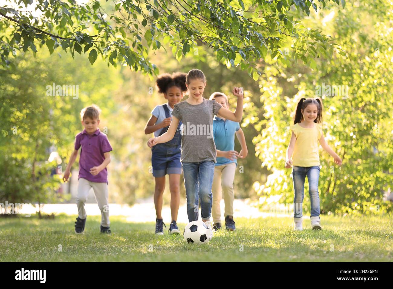 Cute little children playing with ball outdoors on sunny day Stock ...