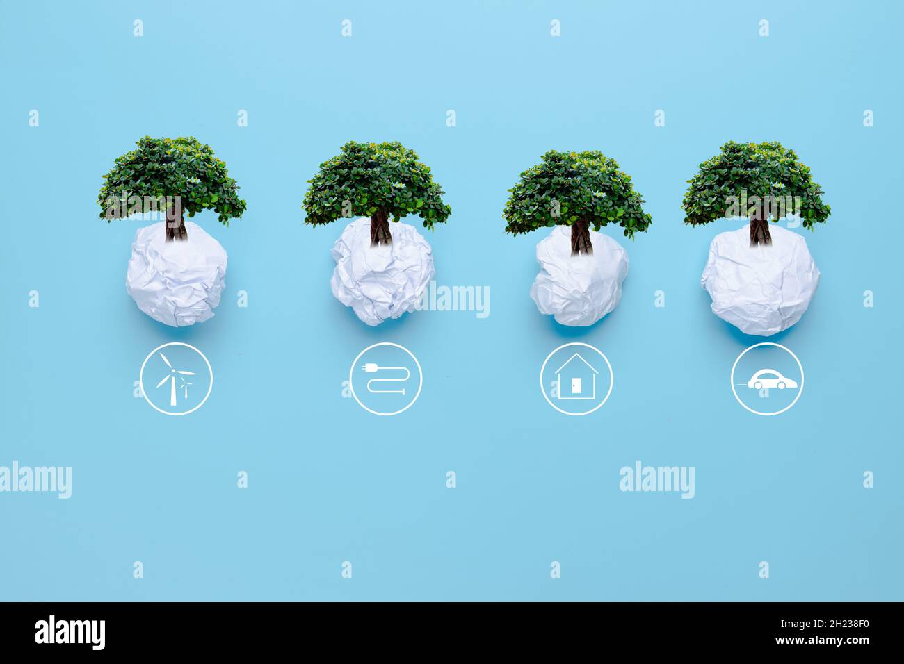 waste paper with big tree on blue background with icons energy sources for renewable, solar cells energy, sustainable development. Ecology and environ Stock Photo