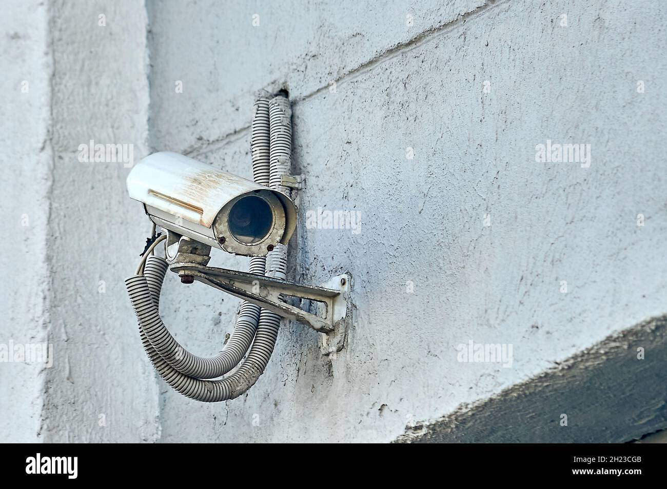 A security camera is hanging on a concrete post Stock Photo - Alamy