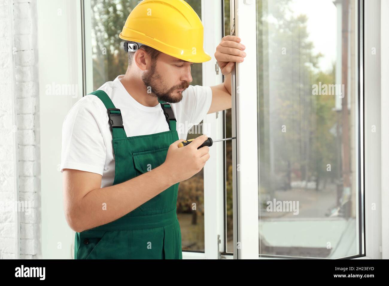 Construction worker installing new window in house Stock Photo - Alamy