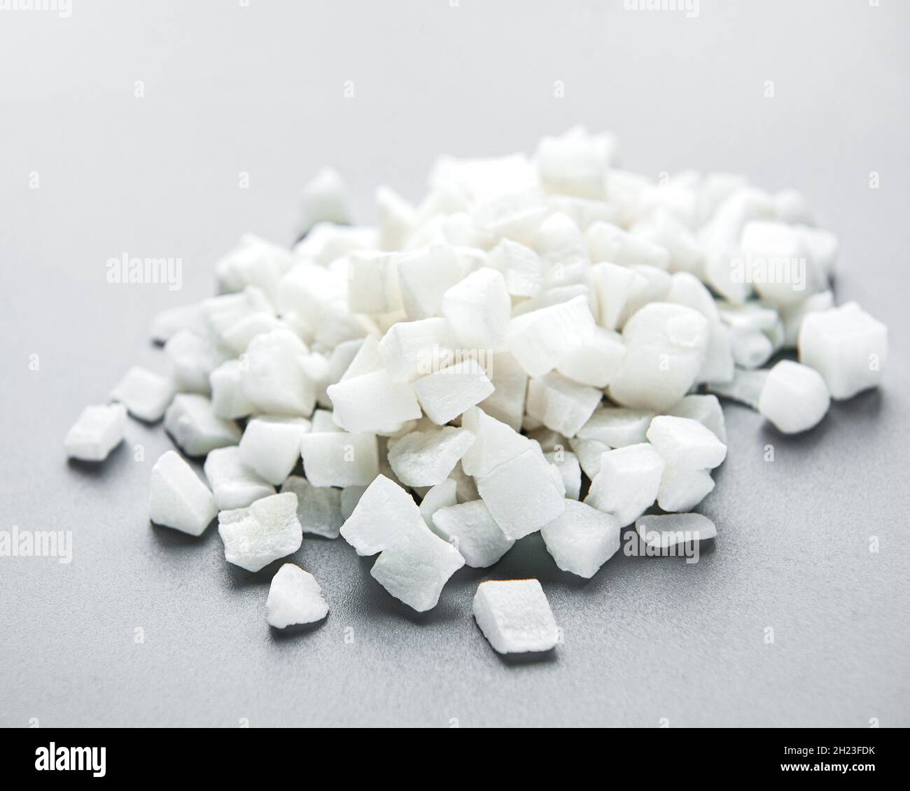 Dried sweet coconut cubes on a white background. Stock Photo