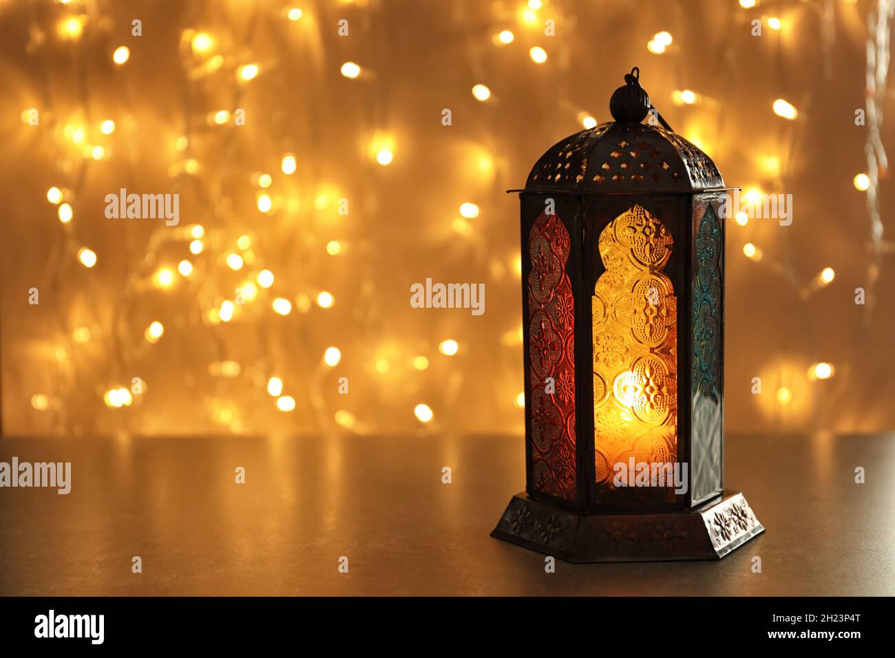 Muslim lamp with candle on table against blurred fairy lights. Fanous as  Ramadan symbol Stock Photo - Alamy