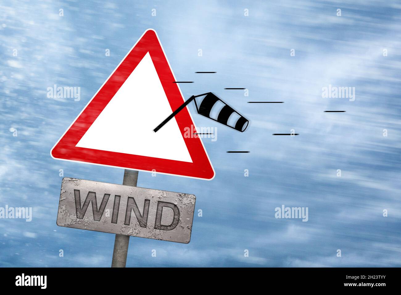 Wind warning sign getting blown away by a storm Stock Photo