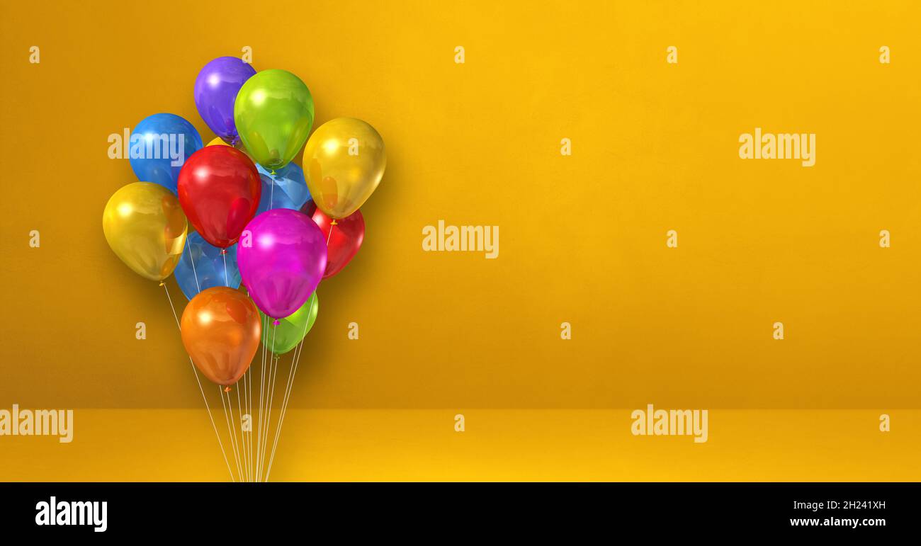 Colorful balloons bunch on a yellow wall background. Horizontal banner ...