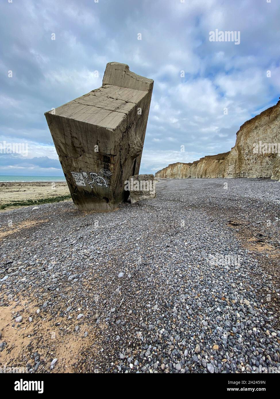 Ein riesiger Bunker des Atlantikwalls ist bei Sainte-Marguerite-sur-Meer von den Kreidefelsen gestürzt. Jetzt steht er aufrecht am Strand. Stock Photo