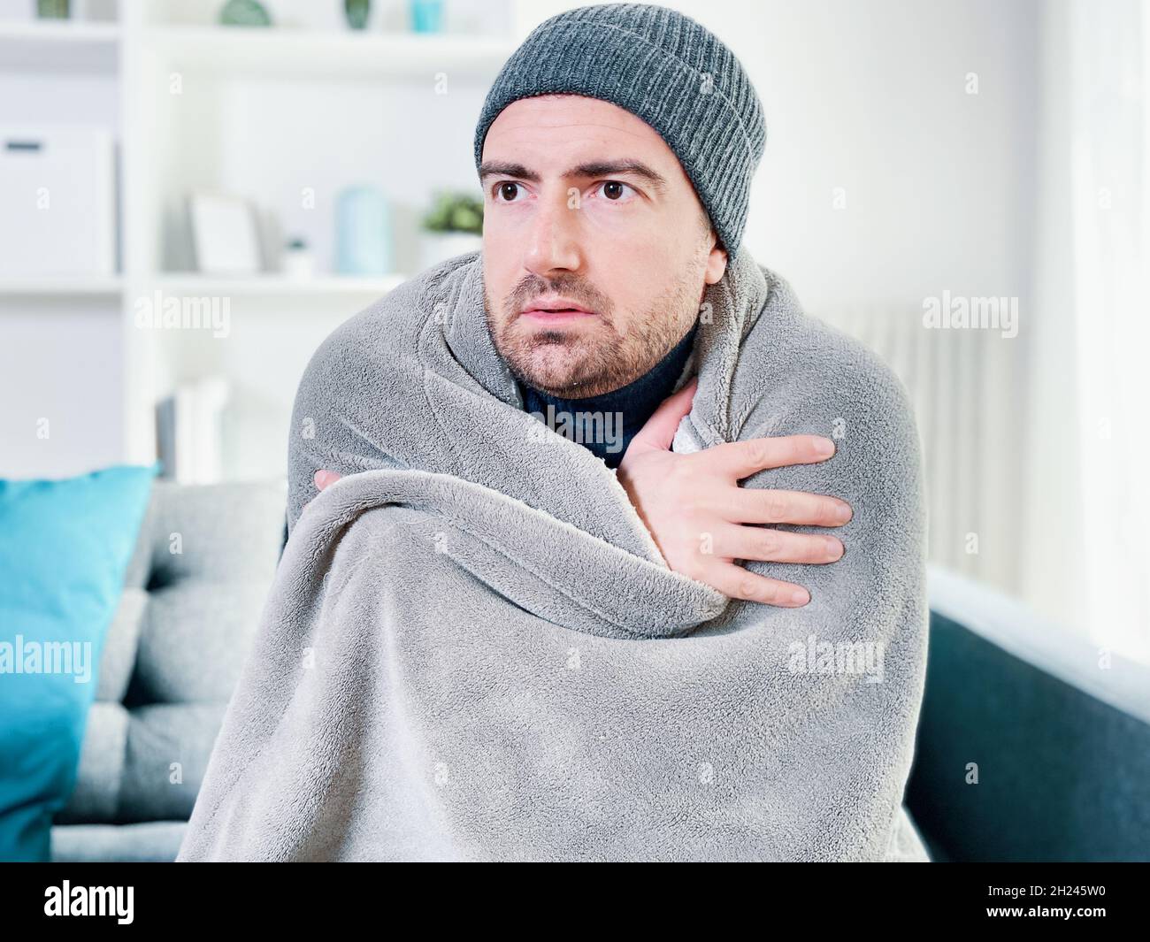Man suffering cold at home and problem with house heating Stock Photo