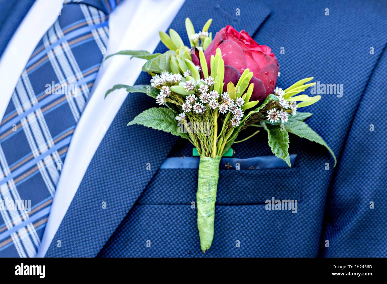 Wedding boutonniere of the groom on a blue suit. Wedding floristry. Ready for wedding ceremony. Close-up Stock Photo