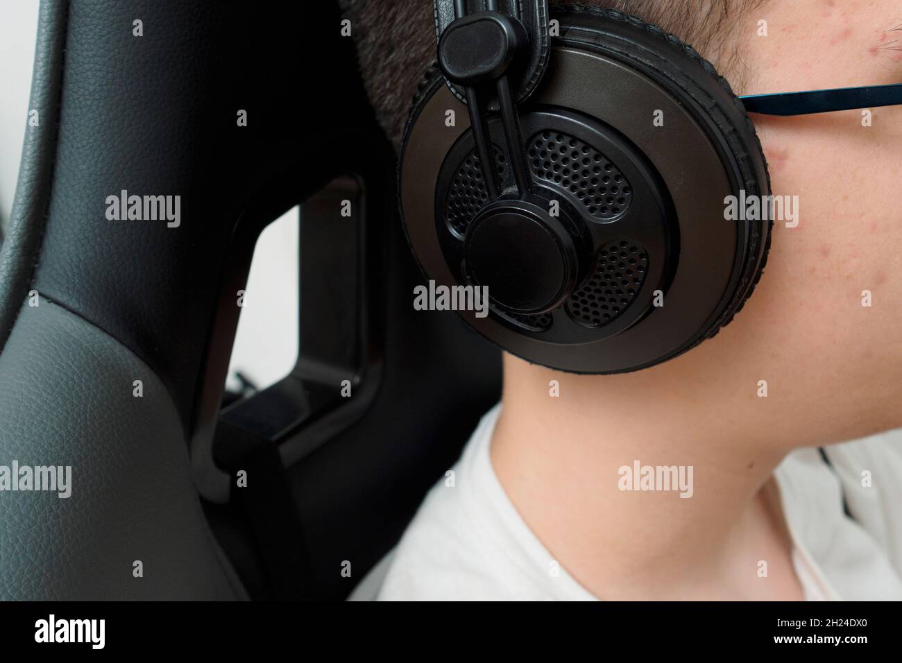 A young gamer with headphones boy playing a computer game on a powerful ...