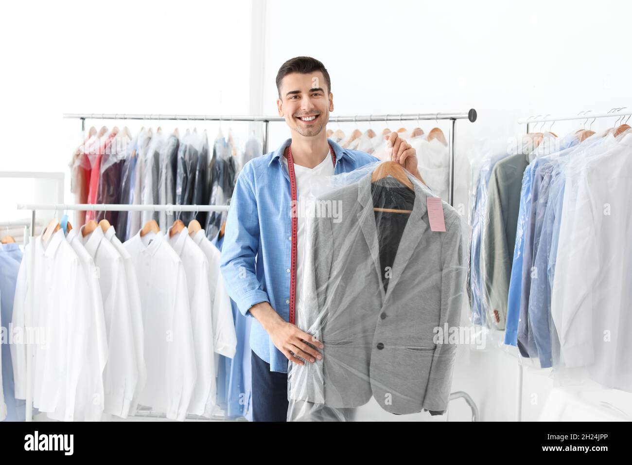 https://c8.alamy.com/comp/2H24JPP/young-man-holding-hanger-with-jacket-in-plastic-bag-at-dry-cleaners-2H24JPP.jpg