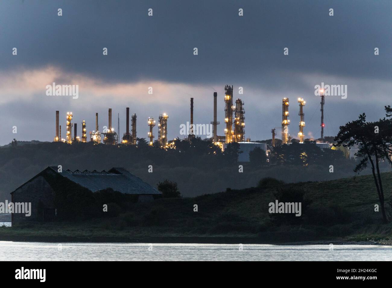 Whitegate, Cork, Ireland. 20th October, 2021. Distillation towers from the oil refinery illuminate around the harbour during blue hour at Whitegate Co. Cork, Ireland. - Picture; David Creedon  / Alamy Live News Stock Photo