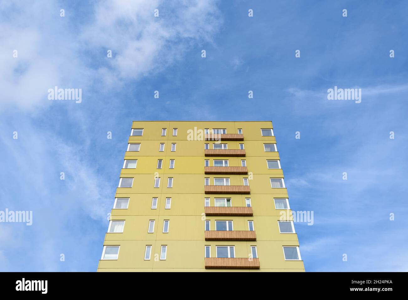 Visual Reference: Tall Green Residential Building Against Blue Sky With Clouds Stock