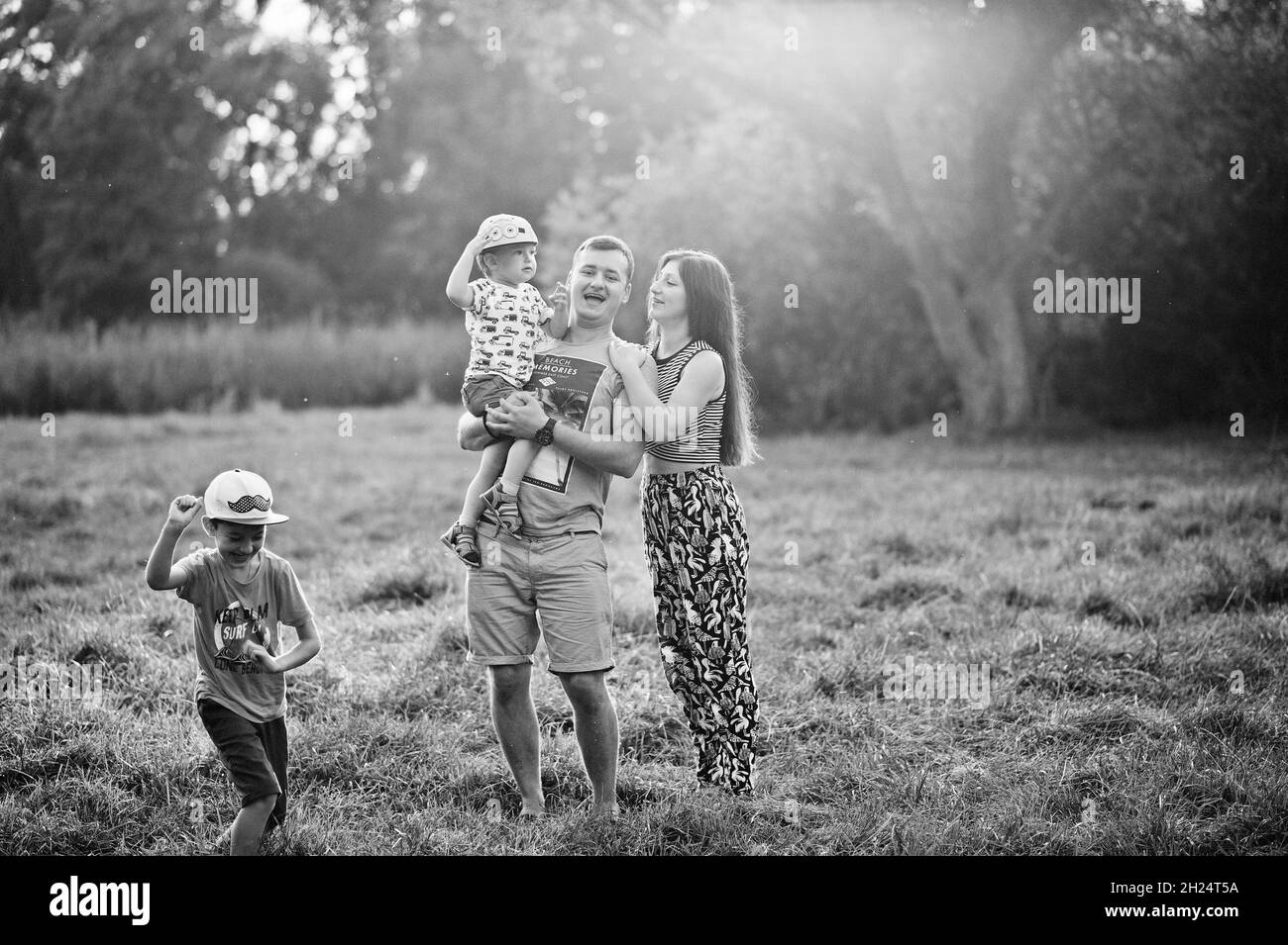 Happy young family: mother, father, two children son on nature having fun. Stock Photo