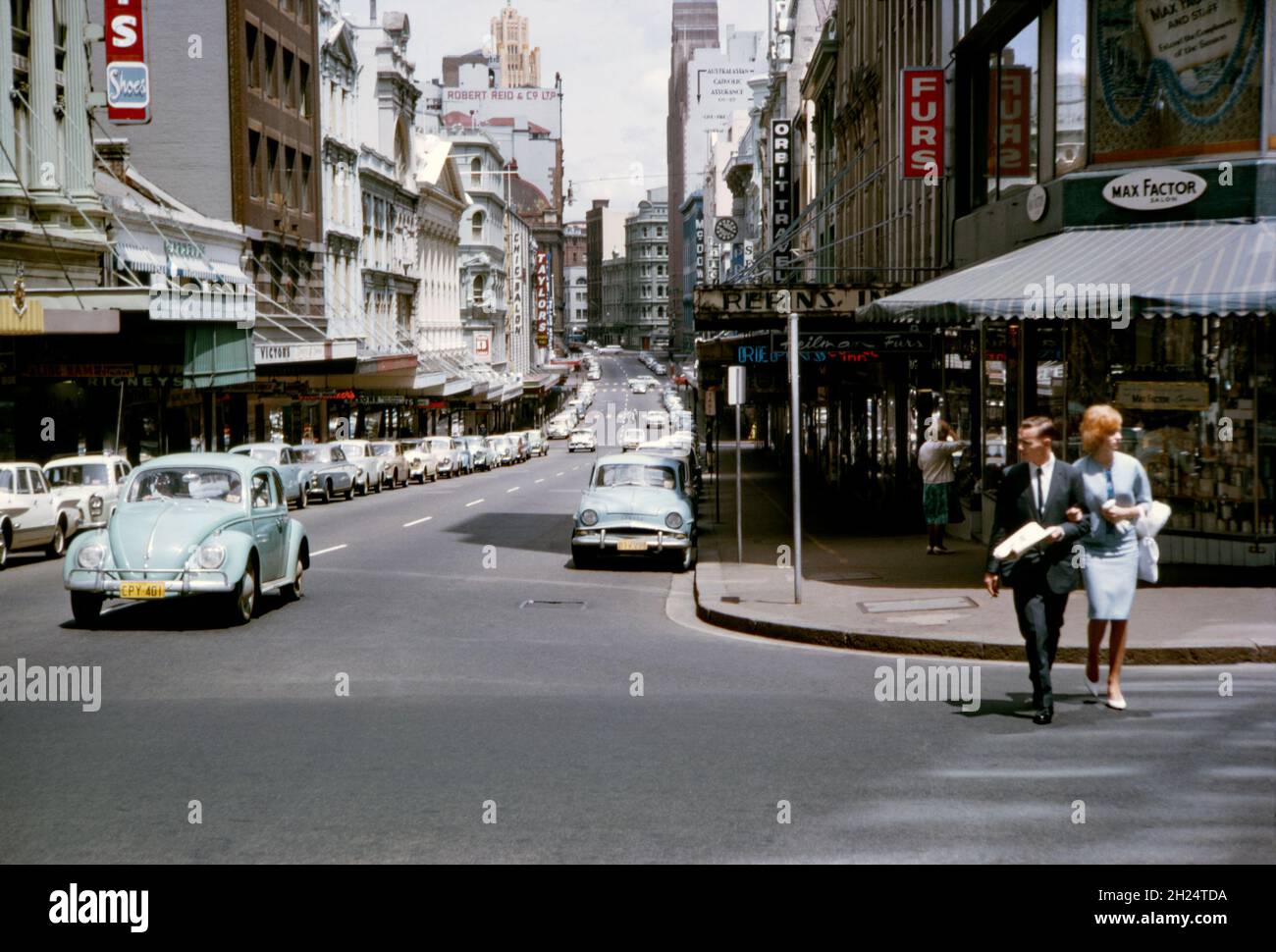 A view looking west down King Street, Sydney, NSW, Australia in 1964 from its intersection with Castlereagh Street. The normally busy street seems very quiet so it could well be a Sunday. The area is much changed and all the shops on the near right are now gone, replaced by the tower and shopping complex of the MLC Centre. King Street is a street in the city centre of Sydney. This image is from an old amateur Kodak colour transparency – a vintage 1960s photograph. Stock Photo