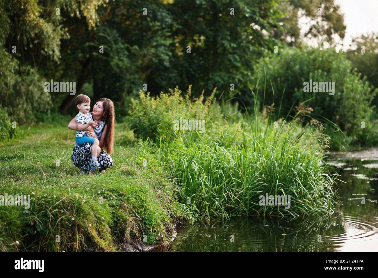 Happy young family: mother with children son on nature having fun. Stock Photo