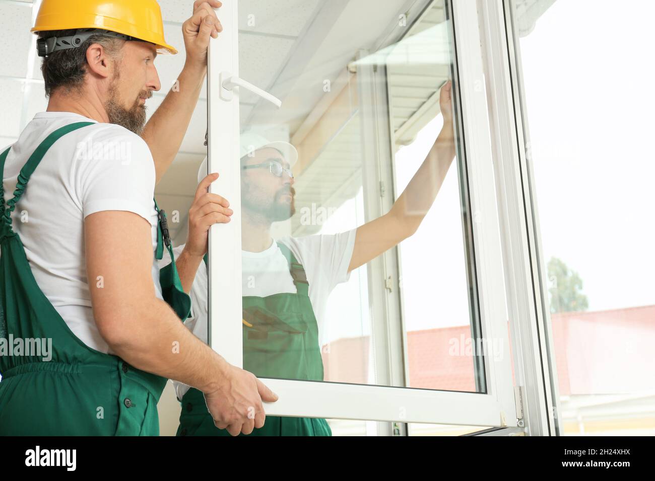 Construction workers installing new window in house Stock Photo - Alamy