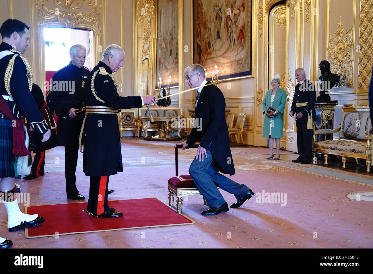 Sir Philip May, the husband of former prime minister Theresa May (watching at right), is knighted for political service by the Prince of Wales during an investiture ceremony at Windsor Castle. Picture date: Wednesday October 20, 2021. Stock Photo