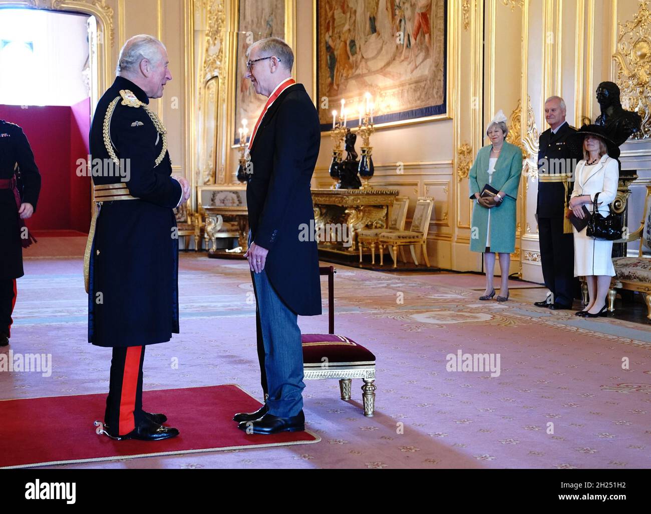 Sir Philip May, the husband of former prime minister Theresa May (watching at third right), is knighted for political service by the Prince of Wales during an investiture ceremony at Windsor Castle. Picture date: Wednesday October 20, 2021. Stock Photo