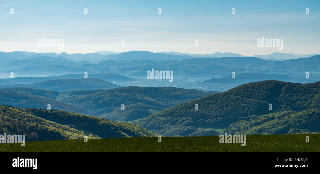 Many mountain ridges viewed from springtime mountain meadow on Machnac hill in Biele Karrpaty mountains in Slovakia near borders with Czech republic d Stock Photo