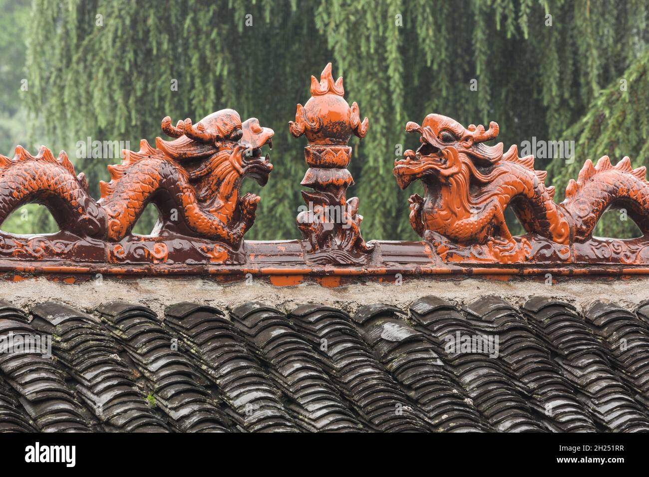 Ceramic dragons facing the pearl of wisdom on a roof crest in the