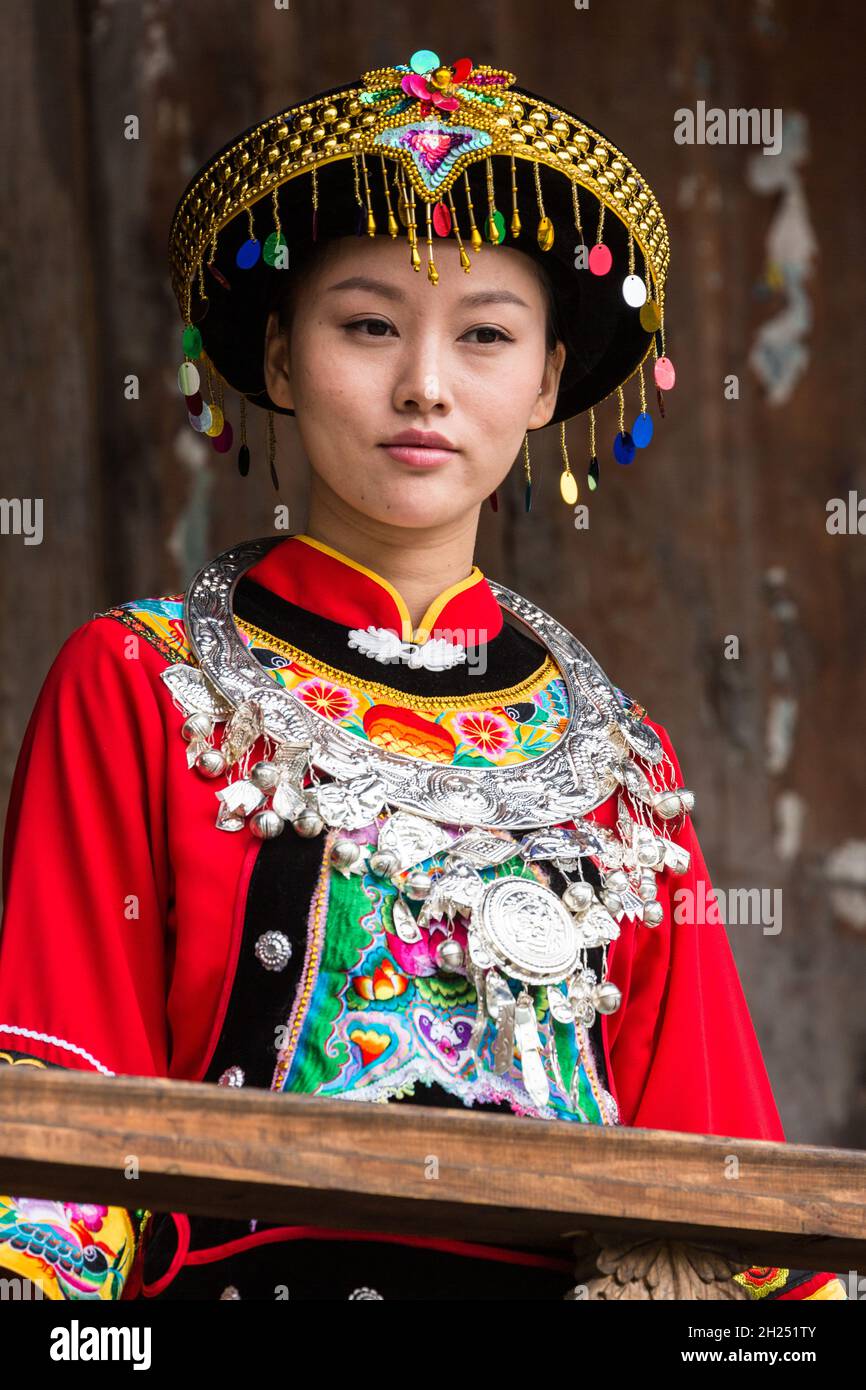 An attractive young woman in traditional ethnic Tujia dress poses for a ...