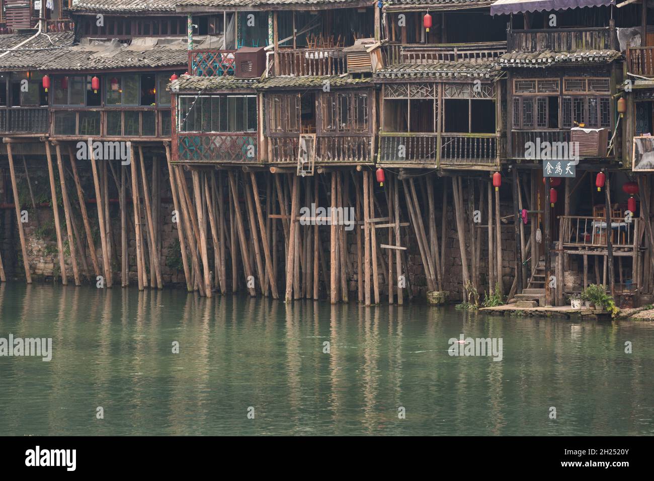 Traditional Diaojiao houses on stilts along the banks of the Tuojiang River.  Ancient town of Fenghuang, China. Stock Photo