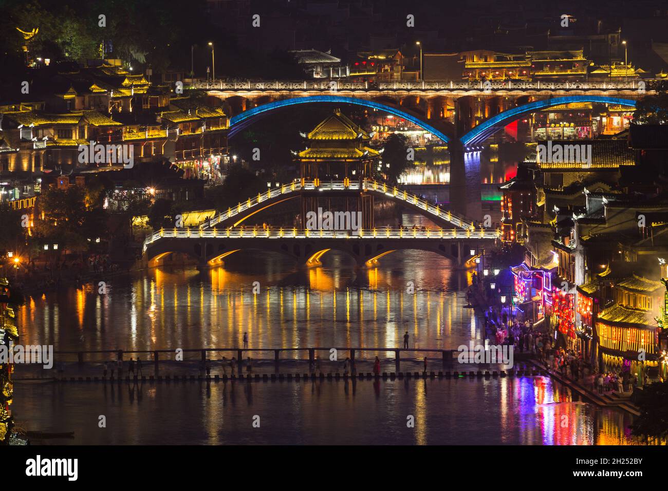 The Fenghuang Bridge and highway bridge over the Tuojiang River, lit at night.  Fenghuang, China. Stock Photo