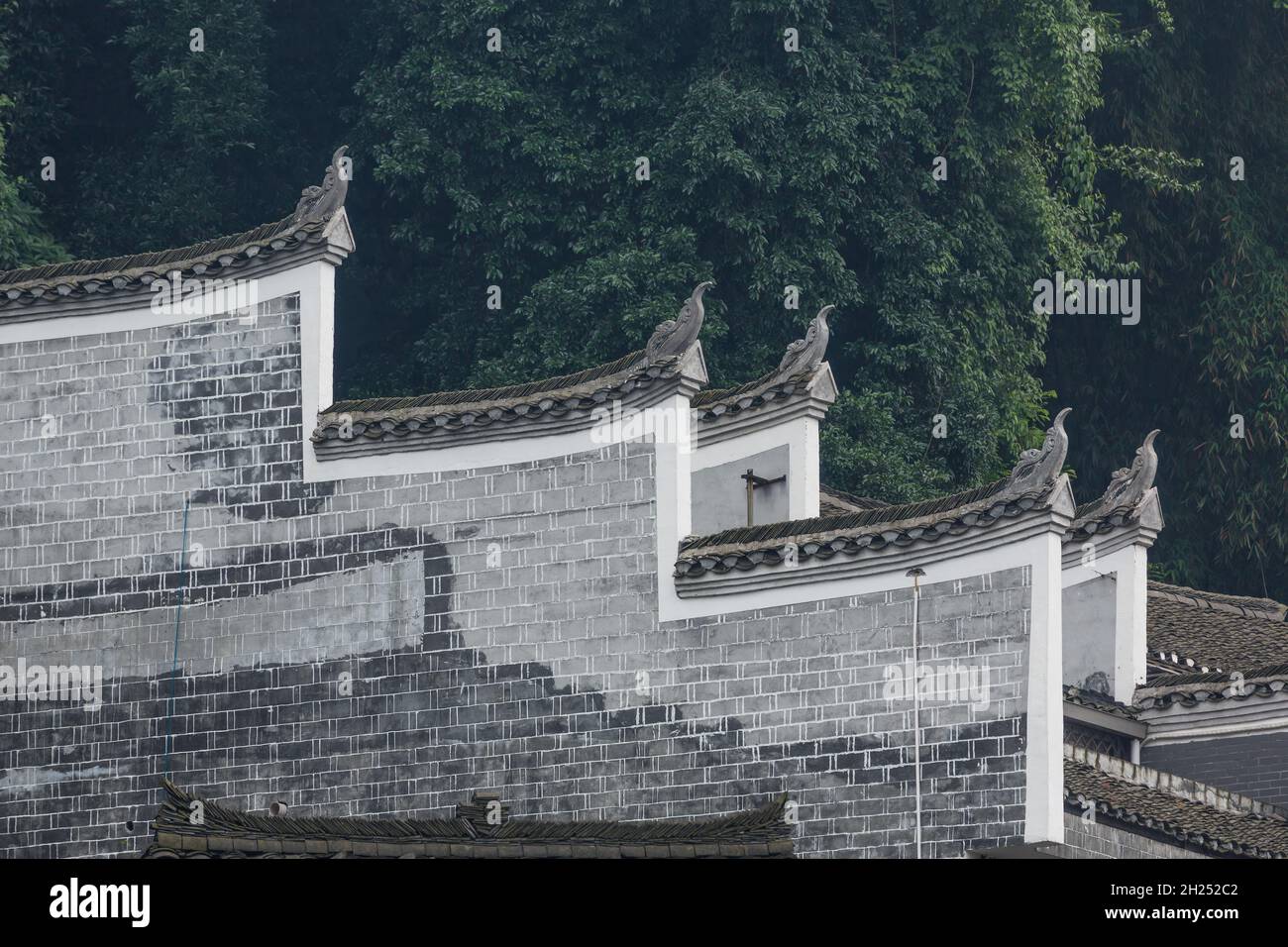 Upturned sculptures representing  phoenix birds on the roof of a traditional building, Fenghuang, China. Stock Photo