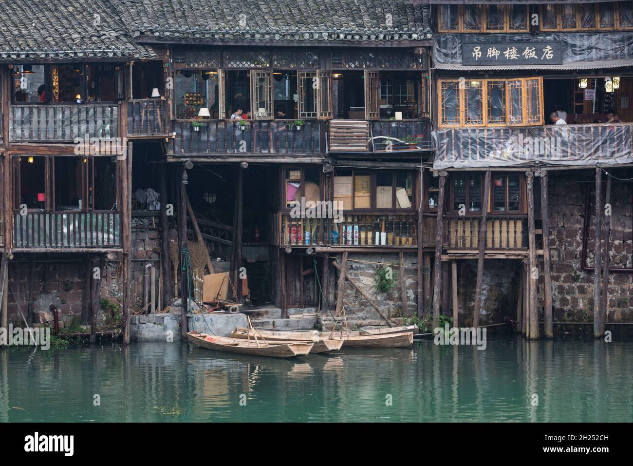 Sampans docked in front Diaojiao-style buildings along the Tuojiang River, Fenghuang, China. Stock Photo