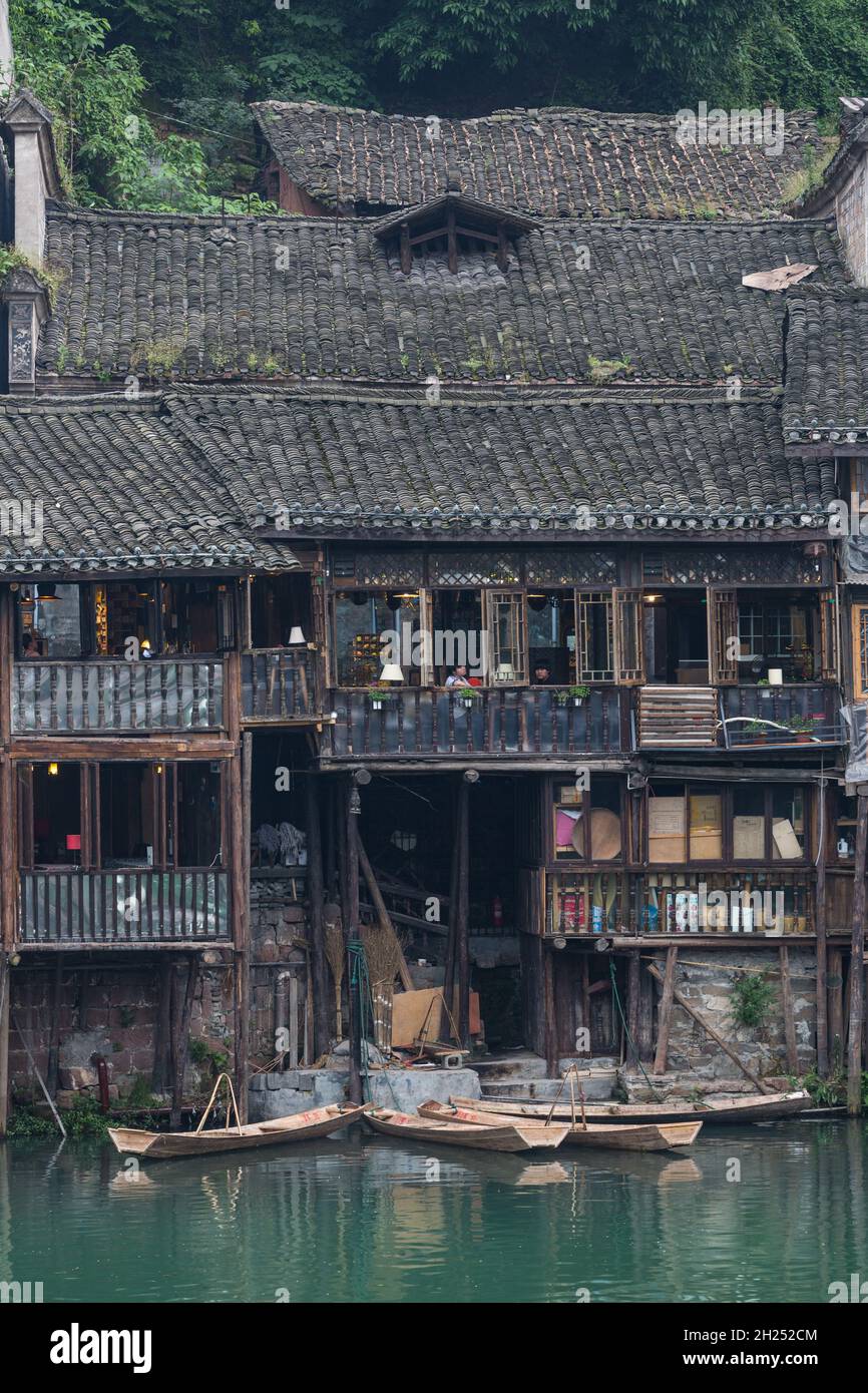 Sampans docked in front Diaojiao-style buildings along the Tuojiang River, Fenghuang, China. Stock Photo