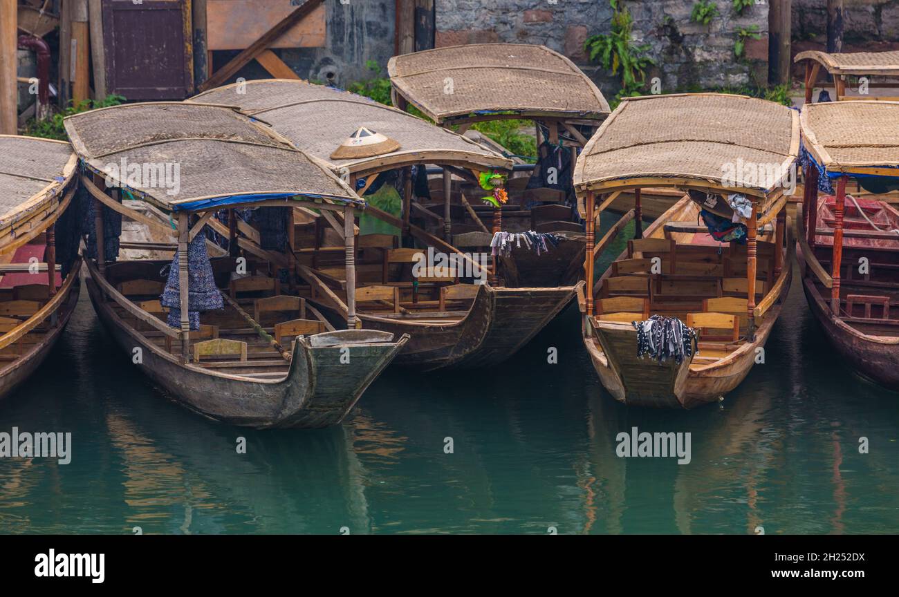 Covered tour boats docked along the Tuojiang River in Fenghuang, China. Stock Photo