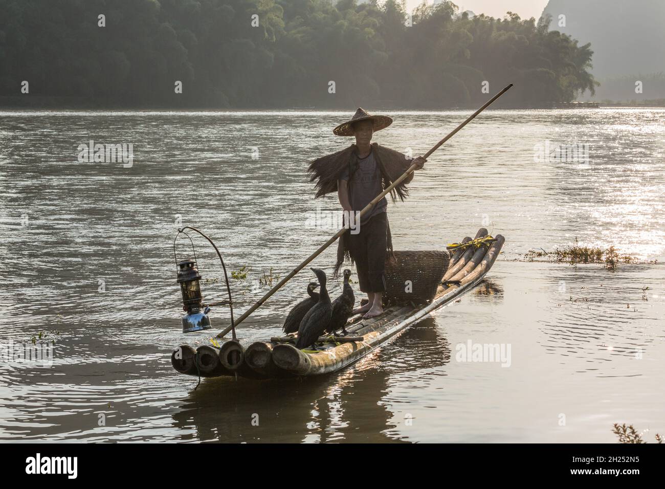 Laos children mending fishing net bamboo poles riverbank trees sunshine  river blue water boys girls Stock Photo - Alamy