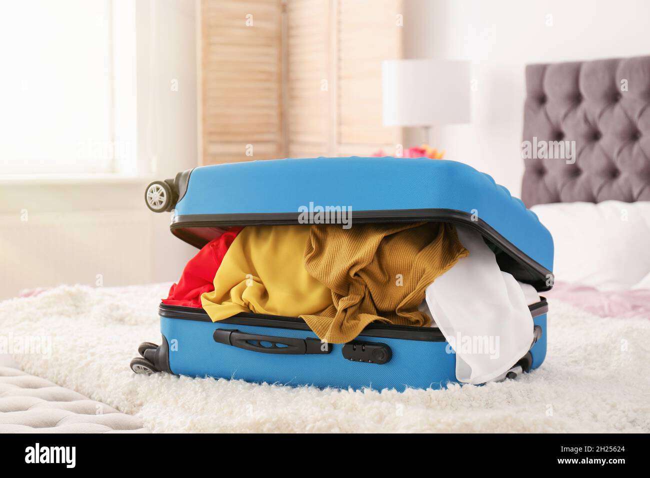 Packed travel suitcase on bed Stock Photo Alamy