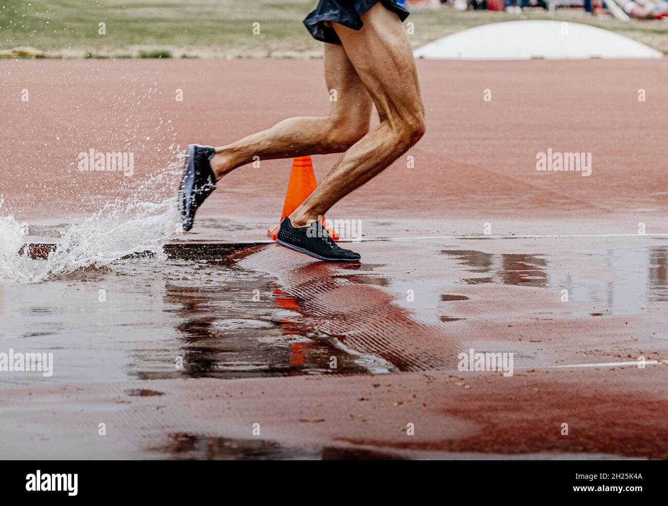 male runner athlete running steeplechase in athletics Stock Photo