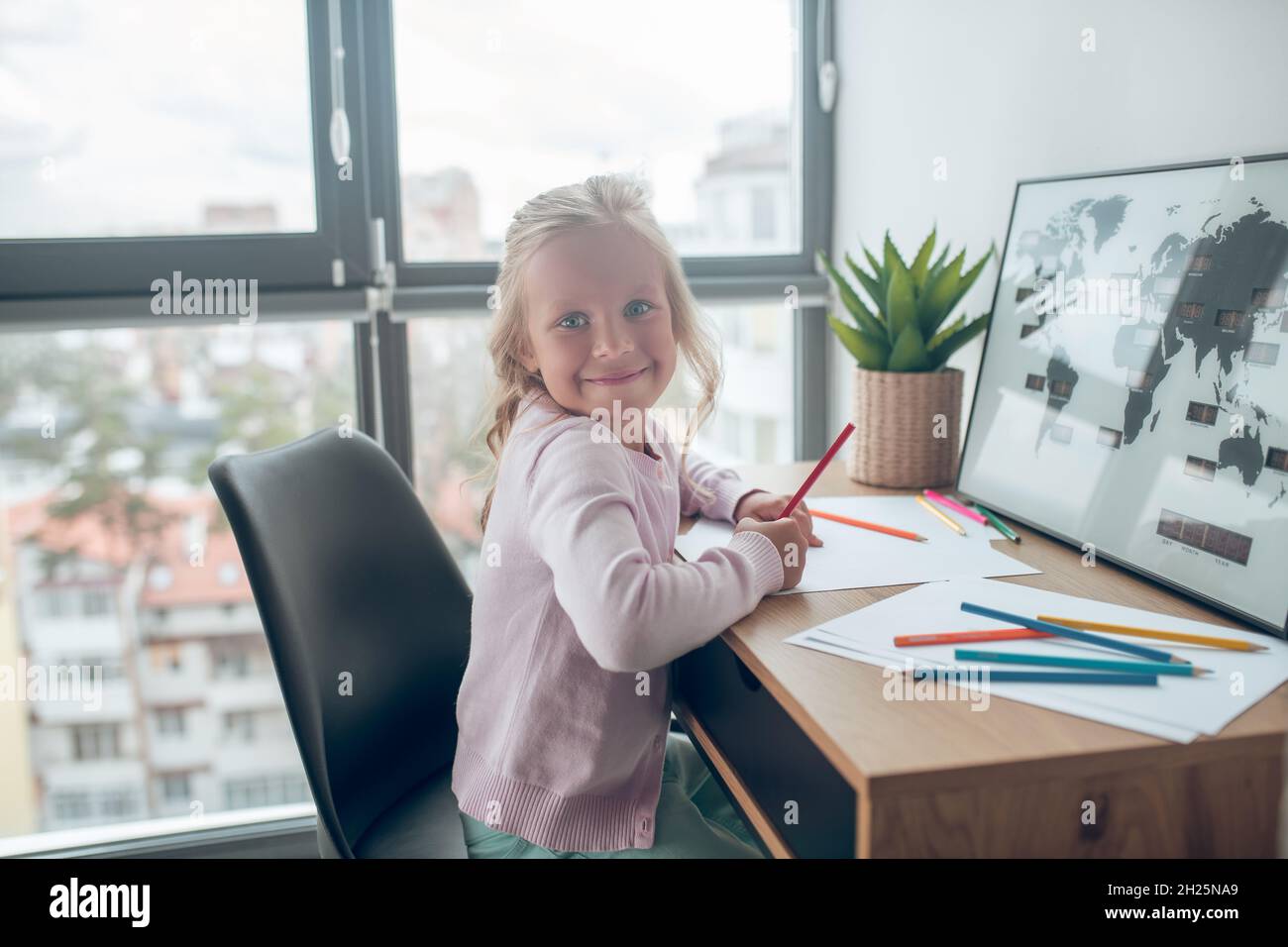 Cute smiling girl sitting table hi-res stock photography and images - Alamy