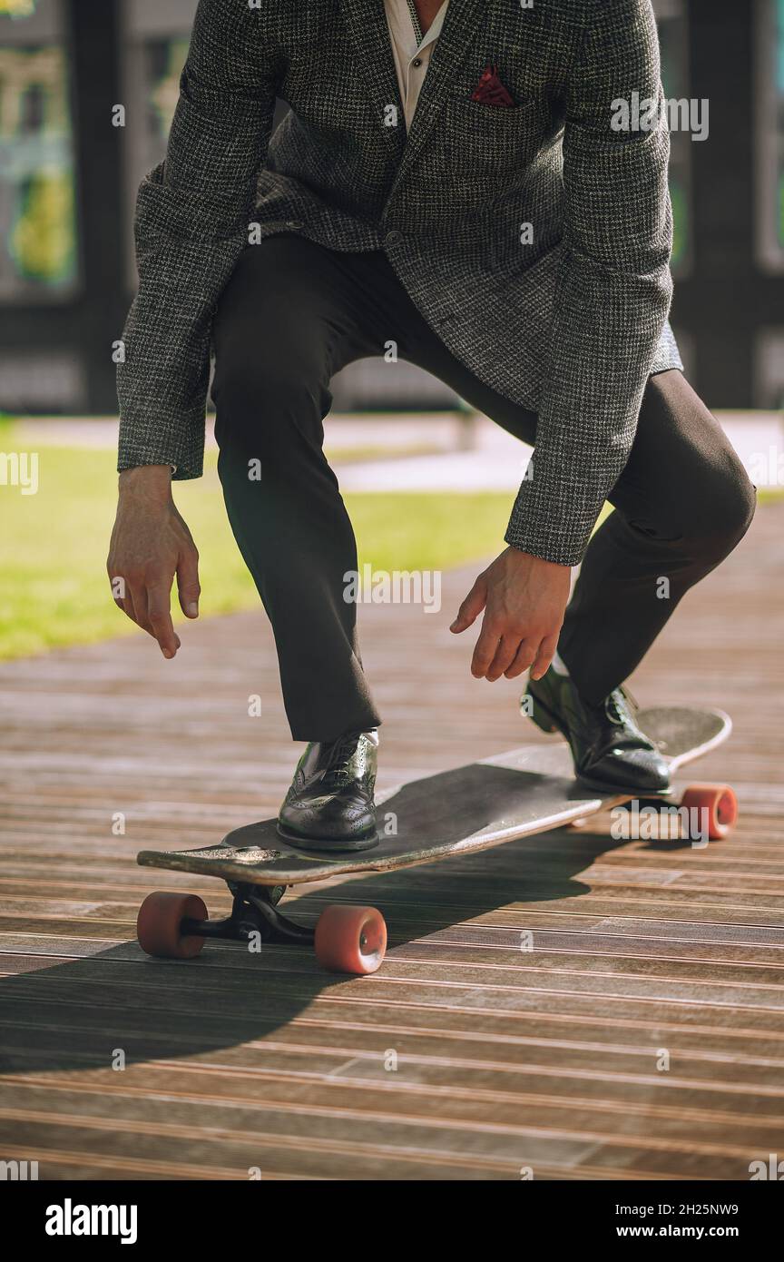Elegant athletic man skateboarding in the morning Stock Photo