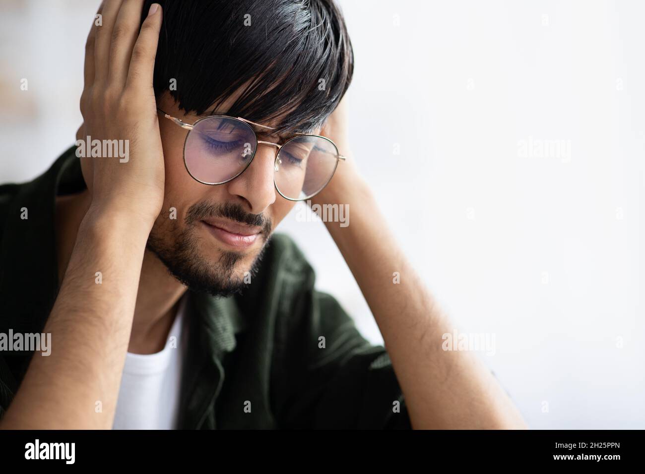 Indian guy touching his head, suffering from migraine Stock Photo