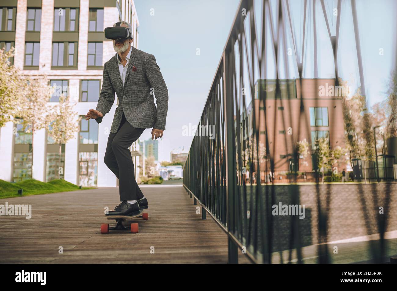 Mature Caucasian man skateboarding in the residential area Stock Photo