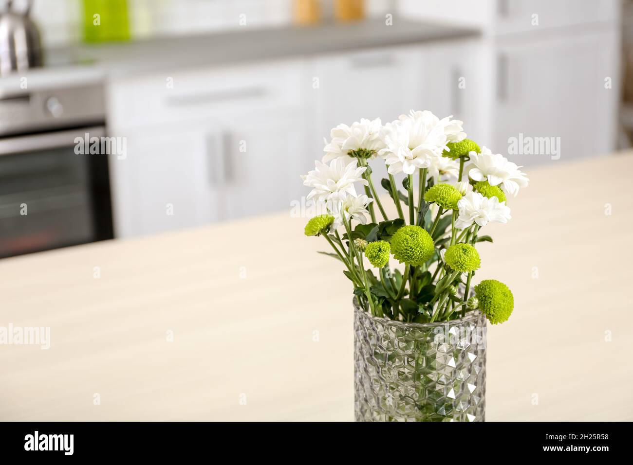 https://c8.alamy.com/comp/2H25R58/vase-with-beautiful-flowers-on-table-in-kitchen-interior-space-for-text-2H25R58.jpg