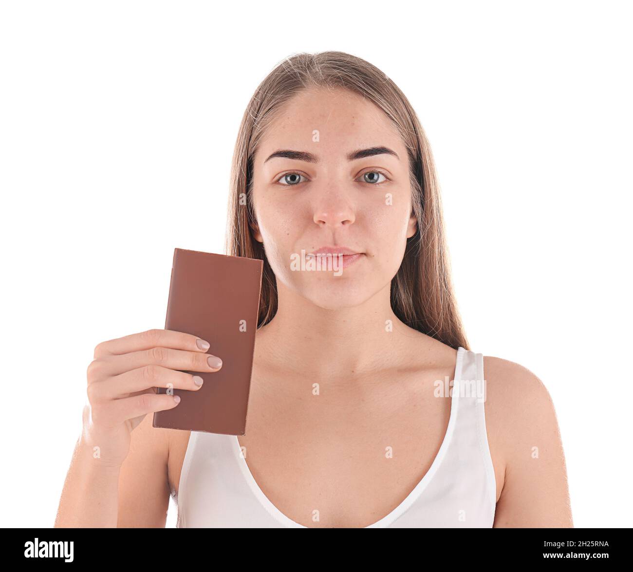 Young woman with acne problem holding chocolate bar on white background
