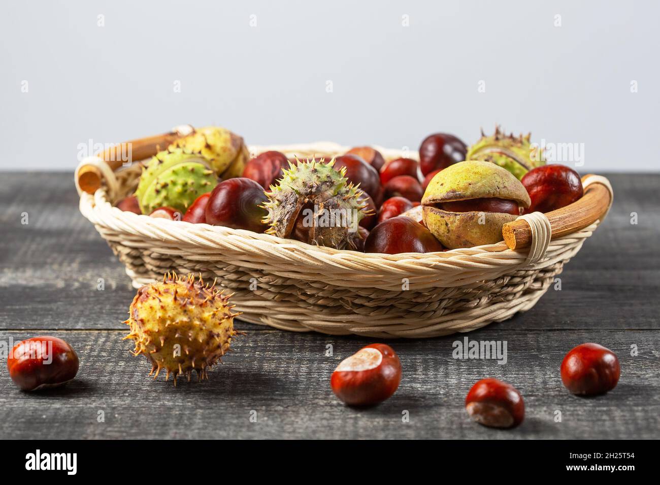 Chestnuts in a basket on a wooden background. Stock Photo
