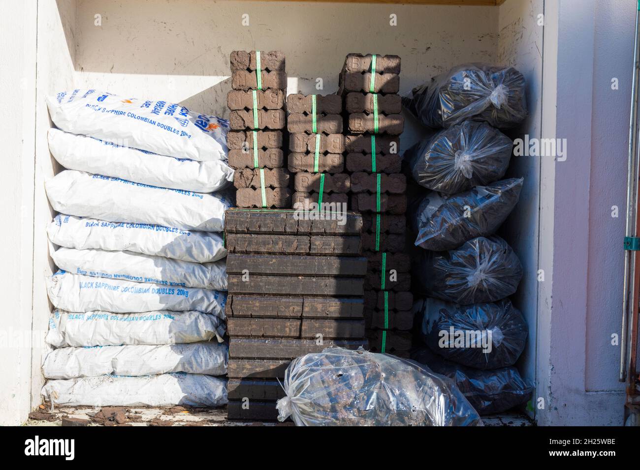 Fossil fuels, turf, peat, coal and peat  briquettes on sale in Ardara, County Donegal, Ireland. Stock Photo