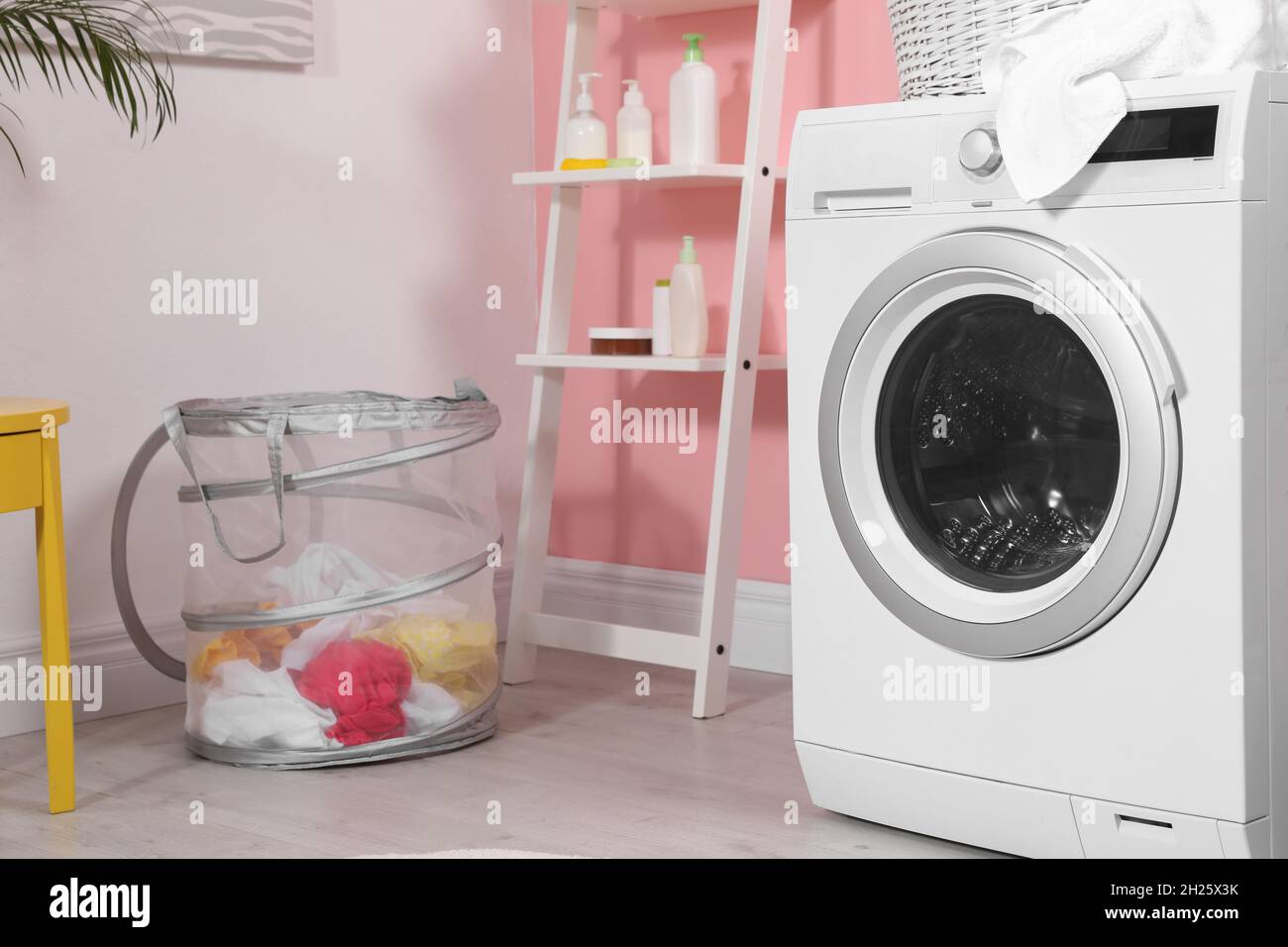 Modern washing machine near wall in laundry room Stock Photo Alamy
