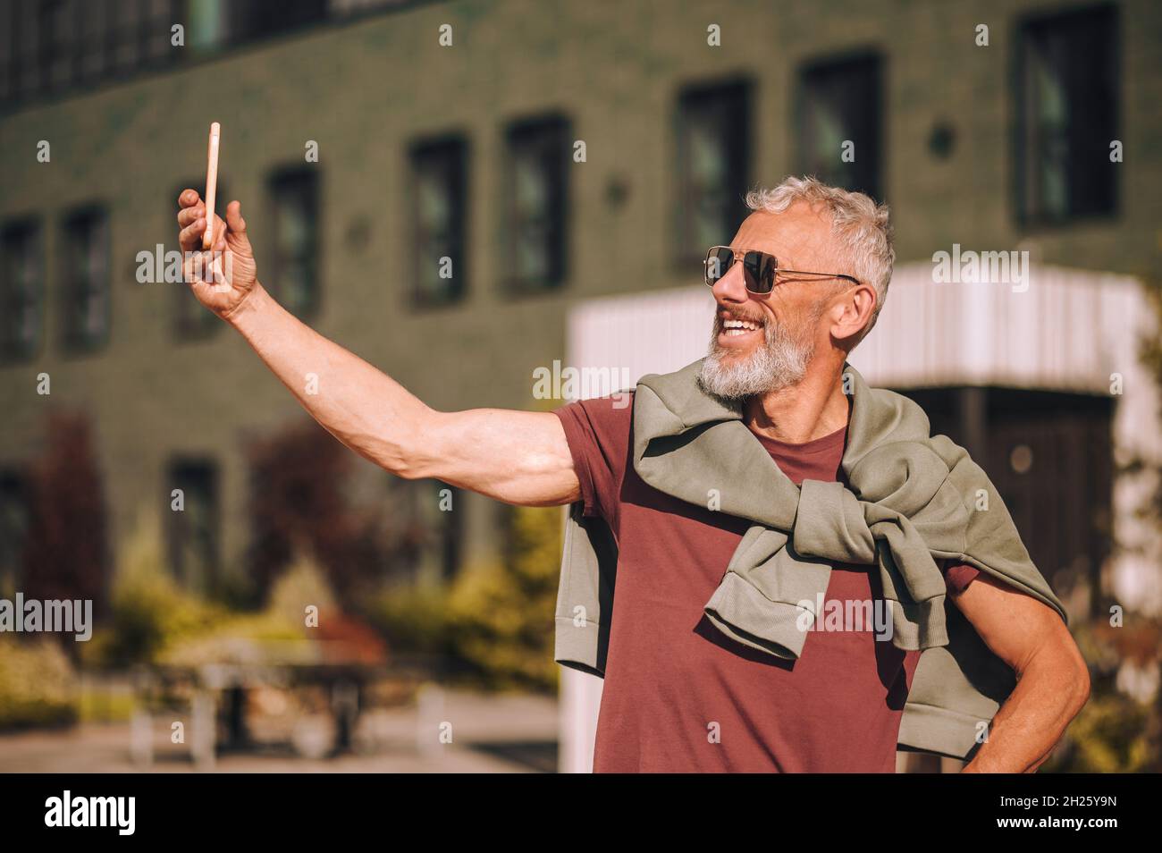 Joyous man photographing himself with his smartphone Stock Photo