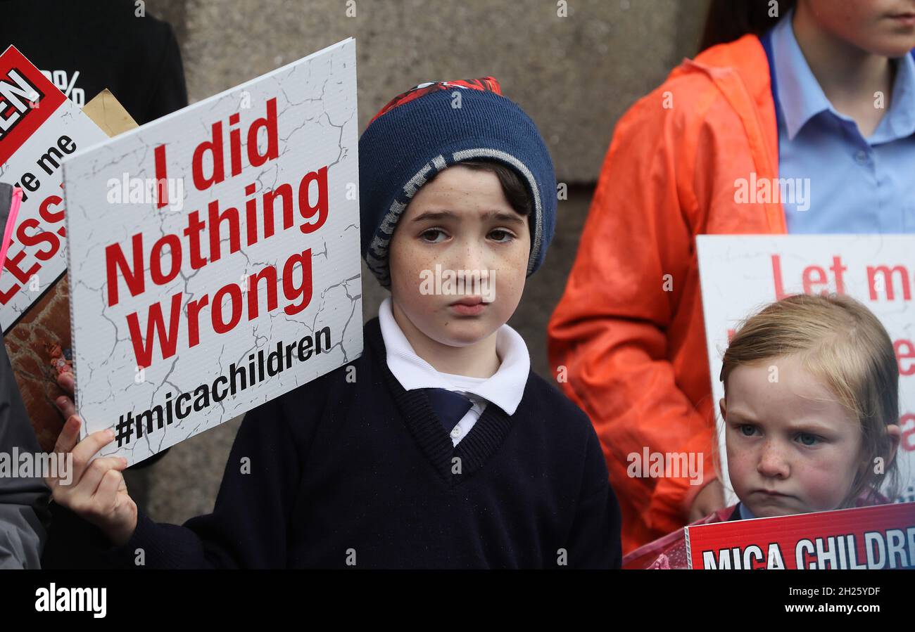 ***PARENTAL PERMISSION GIVEN*** Oliver Kearns (9), from Burnfoot, and Mary-Kate Gill (5), from Moville, at the gates of the Dail on Kildare street, Dublin, as children from across Donegal protest to highlight the ongoing mica crisis. Picture date: Wednesday October 20, 2021. Mica home owners whose properties are crumbling due to defective blocks containing excessive deposits of the mineral Mica are demanding that the Government improve a redress scheme to provide 100% of the rebuild and repair costs. Stock Photo